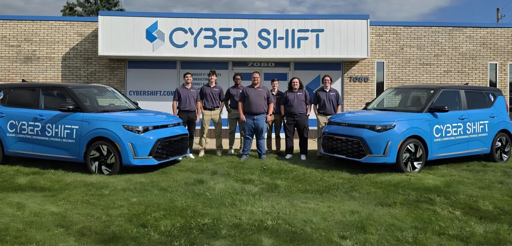 Seven members of the Cyber Shift team standing between two branded vehicles outside the North Canton office. Seven members of the Cyber Shift team standing between two branded vehicles outside the North Canton office.